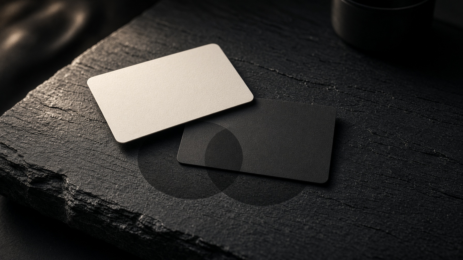 Two overlapping membership cards on black slate